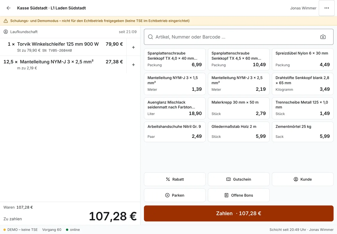 Kasse im Eisenwaren-Demobetrieb: Winkelschleifer mit Seriennummer am Bon und 12,5 m Mantelleitung nach Metern, kein Pfand; rechts Schnelltasten für Schrauben, Kabel und Farbe